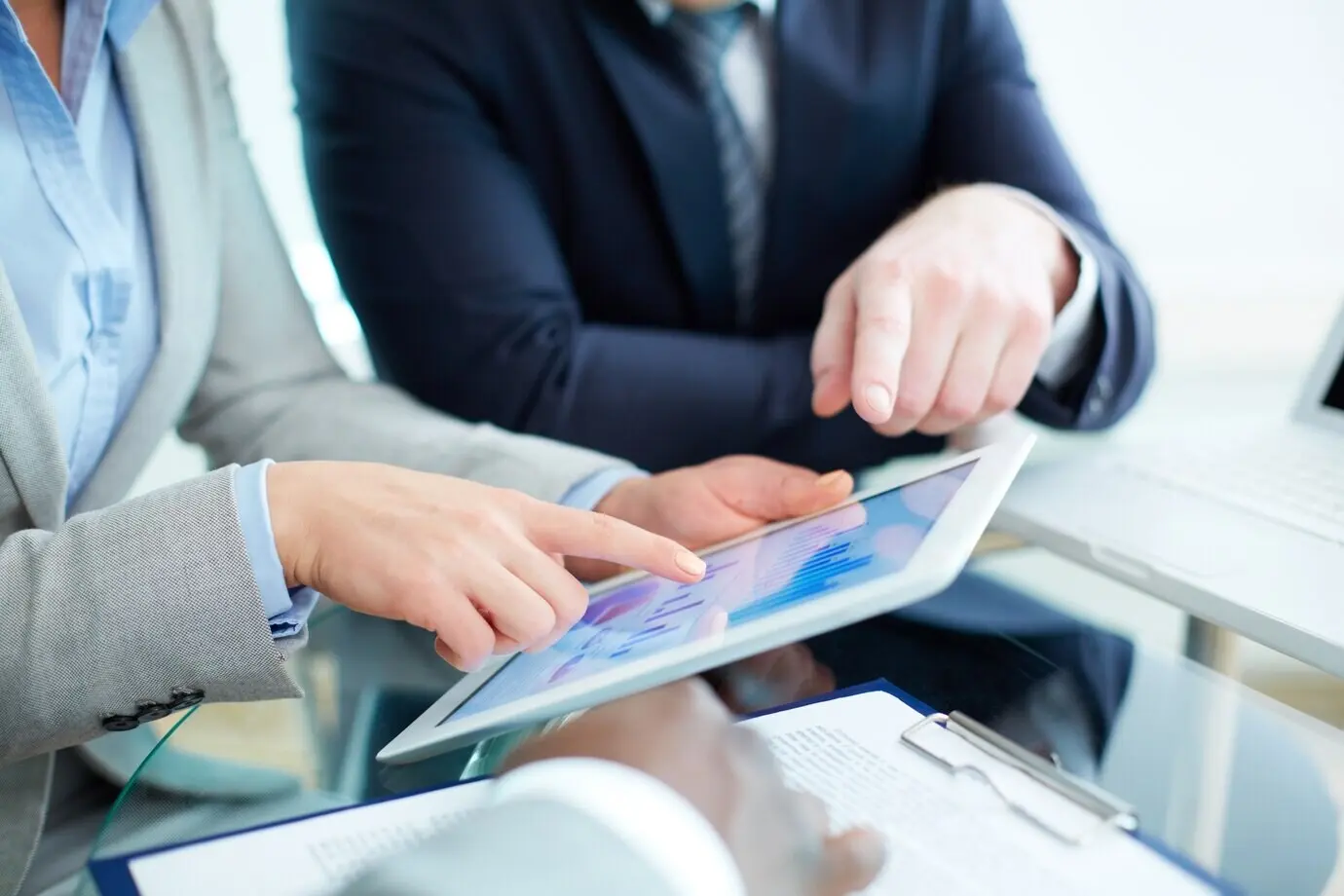 Nahaufnahme einer Geschäftsfrau, die auf ein digitales Tablet zeigt.