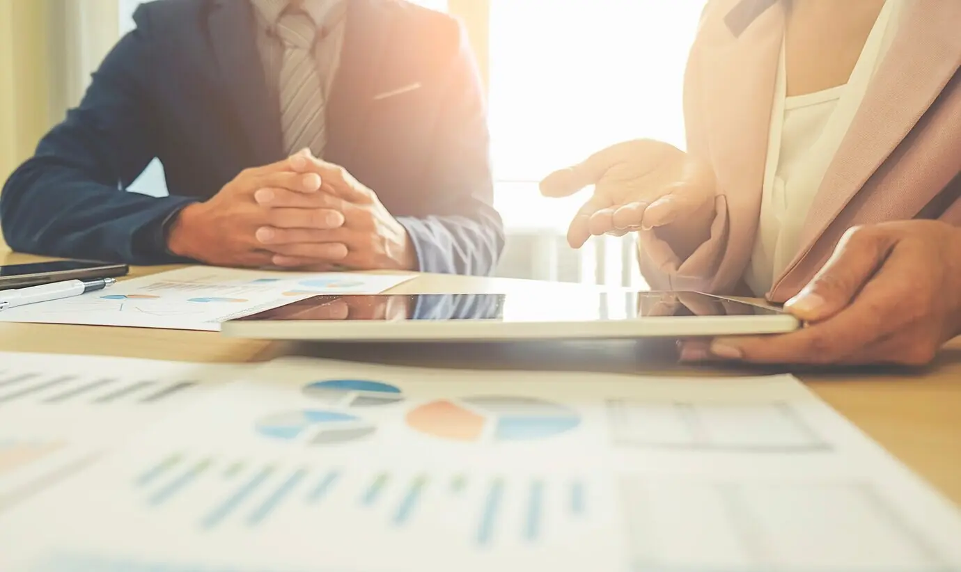 Team im Büro mit Finanzstatistiken und Diagrammen am Arbeitsplatz